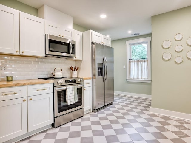 2409 E 37th St, Savannah, GA 31404 - kitchen with stainless steel appliances, light floors, tasteful backsplash, white cabinetry, and recessed lighting
