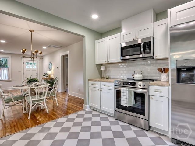 2409 E 37th St, Savannah, GA 31404 - kitchen featuring appliances with stainless steel finishes, light floors, light countertops, white cabinets, and recessed lighting
