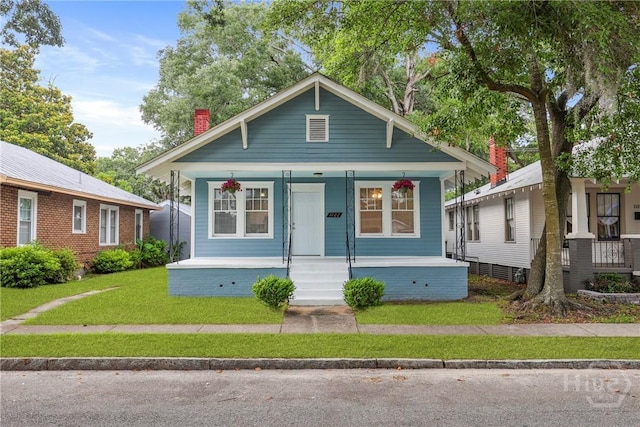 1122 SE 36th St, Savannah, GA 31404 - bungalow featuring covered porch, a chimney, and a front yard