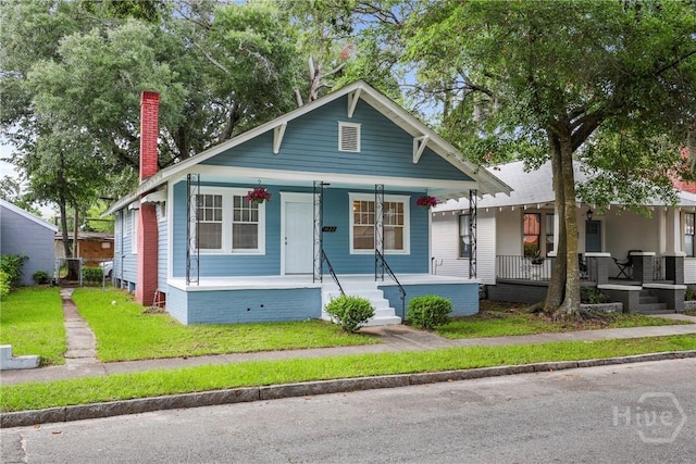 1122 SE 36th St, Savannah, GA 31404 - view of front of house with covered porch, a chimney, and a front lawn