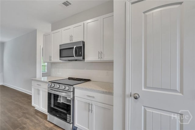 102 Simon Cir, Guyton, GA 31312 - kitchen featuring stainless steel appliances, decorative backsplash, white cabinetry, dark wood-style floors, and light stone counters