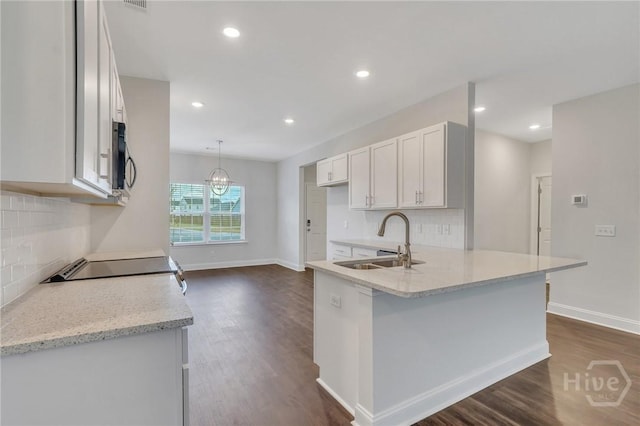 102 Simon Cir, Guyton, GA 31312 - kitchen featuring decorative backsplash, dark wood-type flooring, white cabinetry, a peninsula, and recessed lighting