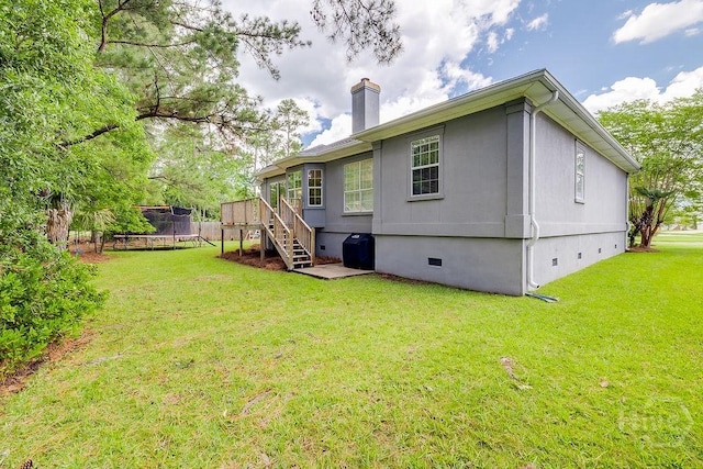 7 Settlers Pt, Savannah, GA 31406 - back of property featuring crawl space, a trampoline, a chimney, a yard, and stairs