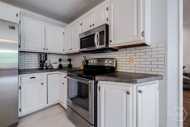 7 Settlers Pt, Savannah, GA 31406 - kitchen with stainless steel appliances, dark countertops, white cabinets, and light marble finish floors