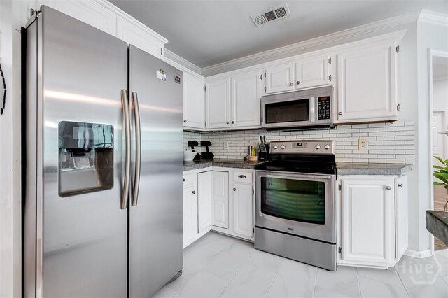 7 Settlers Pt, Savannah, GA 31406 - kitchen featuring appliances with stainless steel finishes, white cabinetry, decorative backsplash, ornamental molding, and light marble finish flooring