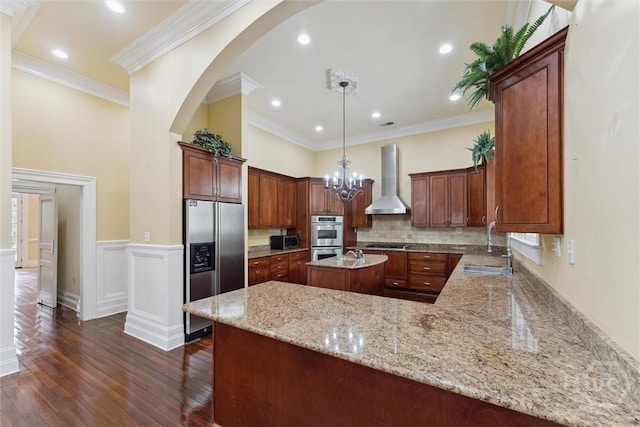 45 Shore Rd, Savannah, GA 31419 - kitchen with wall chimney range hood, stainless steel appliances, dark wood-style flooring, arched walkways, and light stone counters