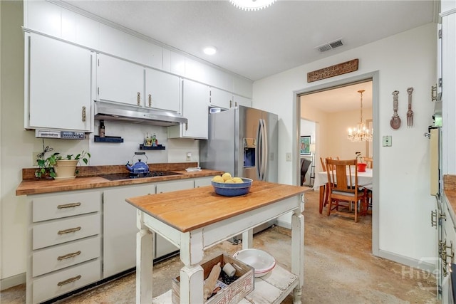 7012 Sandnettles Dr, Savannah, GA 31410 - kitchen with black cooktop, under cabinet range hood, finished concrete floors, white cabinetry, and stainless steel fridge with ice dispenser