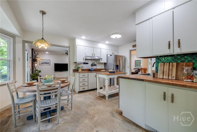 7012 Sandnettles Dr, Savannah, GA 31410 - kitchen with wooden counters, concrete floors, decorative light fixtures, white cabinetry, and tasteful backsplash