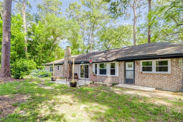 7012 Sandnettles Dr, Savannah, GA 31410 - back of house with a chimney, a patio area, brick siding, and roof with shingles