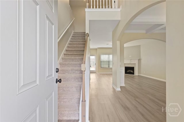 1447 Arnold Dr SE, Allenhurst, GA 31301 - entryway featuring wood finished floors, stairs, a fireplace, crown molding, and arched walkways