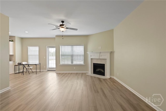 1447 Arnold Dr SE, Allenhurst, GA 31301 - unfurnished living room featuring light wood-style floors, a ceiling fan, and a fireplace