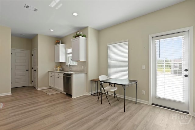 1447 Arnold Dr SE, Allenhurst, GA 31301 - kitchen with stainless steel dishwasher, light wood-style flooring, white cabinets, backsplash, and recessed lighting