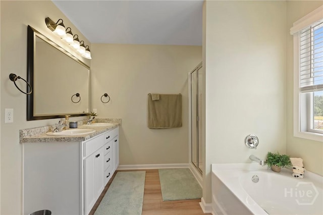 1447 Arnold Dr SE, Allenhurst, GA 31301 - bathroom with a bath, double vanity, wood finished floors, and a stall shower