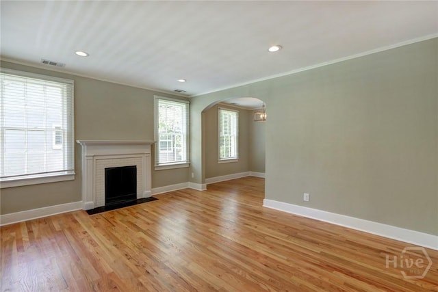 416 E 61st St, Savannah, GA 31405 - unfurnished living room featuring arched walkways, crown molding, light wood finished floors, a fireplace, and recessed lighting