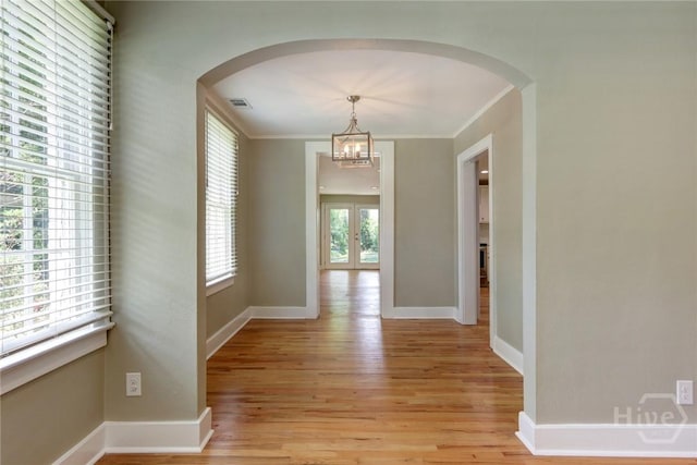 416 E 61st St, Savannah, GA 31405 - corridor featuring light wood-style flooring, arched walkways, a chandelier, and crown molding
