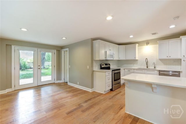 416 E 61st St, Savannah, GA 31405 - kitchen featuring appliances with stainless steel finishes, backsplash, light countertops, light wood-type flooring, and recessed lighting