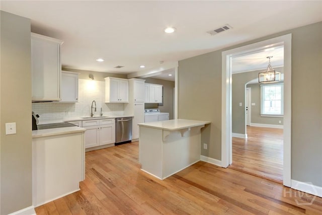 416 E 61st St, Savannah, GA 31405 - kitchen with dishwasher, washing machine and dryer, range, light wood finished floors, and white cabinetry