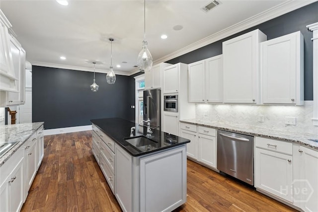 15 Sabal Dr, Richmond Hill, GA 31324 - kitchen with stainless steel appliances, backsplash, white cabinets, a center island with sink, and recessed lighting