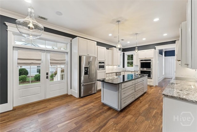 15 Sabal Dr, Richmond Hill, GA 31324 - kitchen featuring stainless steel appliances, ornamental molding, dark wood finished floors, white cabinetry, and a kitchen island with sink