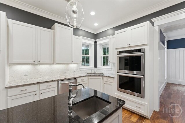 15 Sabal Dr, Richmond Hill, GA 31324 - kitchen featuring stainless steel appliances, backsplash, white cabinets, ornamental molding, and recessed lighting