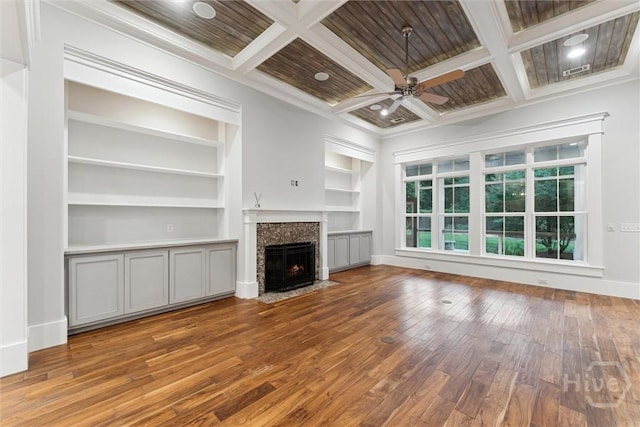 15 Sabal Dr, Richmond Hill, GA 31324 - unfurnished living room featuring wood-type flooring, built in features, a ceiling fan, coffered ceiling, and a fireplace with flush hearth