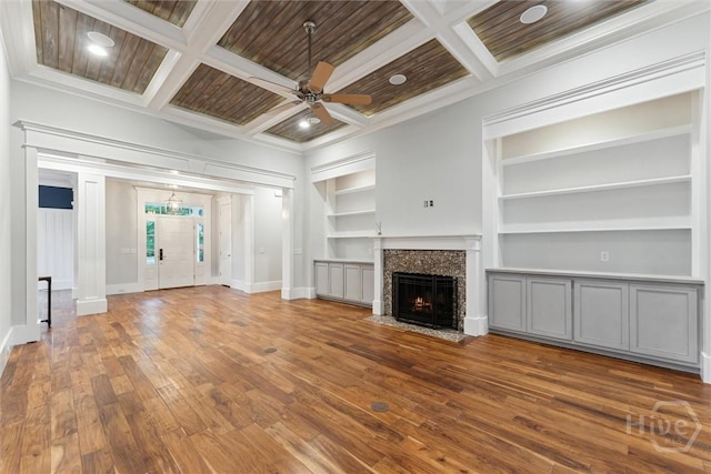 15 Sabal Dr, Richmond Hill, GA 31324 - unfurnished living room featuring coffered ceiling, built in shelves, hardwood / wood-style floors, a ceiling fan, and crown molding