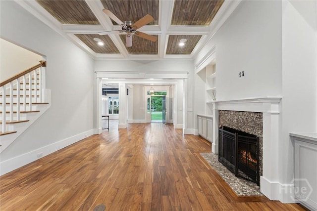 15 Sabal Dr, Richmond Hill, GA 31324 - unfurnished living room with a tiled fireplace, wood-type flooring, ceiling fan, coffered ceiling, and stairs