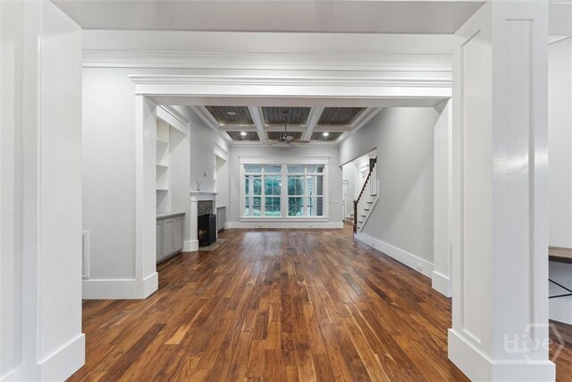 15 Sabal Dr, Richmond Hill, GA 31324 - unfurnished living room featuring stairs, dark wood-style floors, coffered ceiling, ornamental molding, and a fireplace with flush hearth