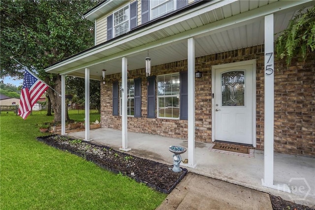 75 Brown Thrasher Ct, Richmond Hill, GA 31324 - property entrance featuring a porch, a yard, and brick siding