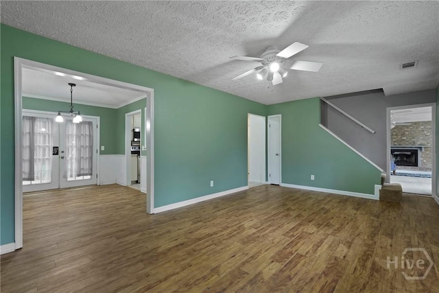 75 Brown Thrasher Ct, Richmond Hill, GA 31324 - unfurnished living room with a ceiling fan, wood finished floors, a textured ceiling, and a stone fireplace