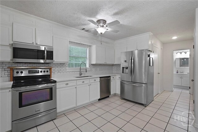 75 Brown Thrasher Ct, Richmond Hill, GA 31324 - kitchen with appliances with stainless steel finishes, light countertops, ceiling fan, white cabinetry, and backsplash