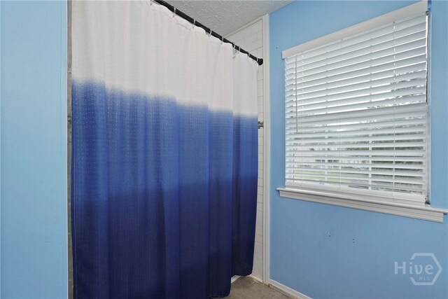 75 Brown Thrasher Ct, Richmond Hill, GA 31324 - bathroom featuring a textured ceiling and a shower with shower curtain