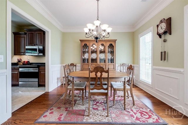 144 Sweetwater Cir, Rincon, GA 31326 - dining area with a chandelier, crown molding, dark wood finished floors, wainscoting, and a decorative wall