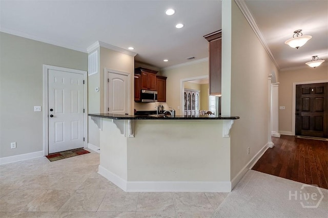 144 Sweetwater Cir, Rincon, GA 31326 - kitchen featuring stainless steel microwave, crown molding, a kitchen breakfast bar, recessed lighting, and a peninsula