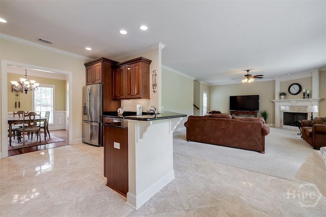 144 Sweetwater Cir, Rincon, GA 31326 - kitchen featuring stainless steel fridge, a breakfast bar area, crown molding, a chandelier, and a ceiling fan