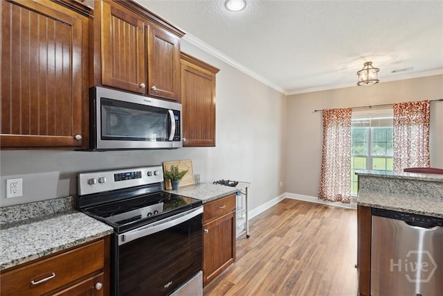 112 Kingsley Dr N, Guyton, GA 31312 - kitchen featuring appliances with stainless steel finishes, crown molding, light wood-style flooring, and light stone countertops