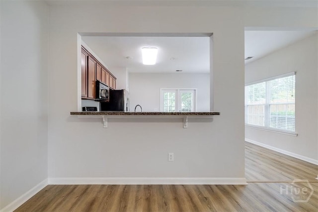 7 Hartland Ct, Savannah, GA 31407 - kitchen featuring black microwave, freestanding refrigerator, wood finished floors, and a kitchen bar