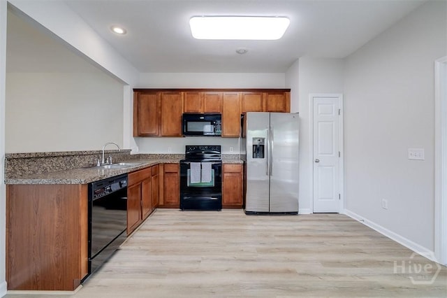 7 Hartland Ct, Savannah, GA 31407 - kitchen with black appliances, brown cabinets, light wood-type flooring, and recessed lighting