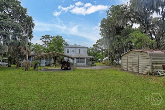 206 Bonaventure Rd, Thunderbolt, GA 31404 - back of house featuring a detached carport, a lawn, and a storage unit
