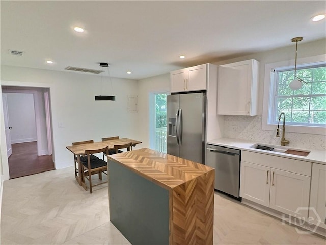 417 E 65th St, Savannah, GA 31405 - kitchen with appliances with stainless steel finishes, white cabinetry, recessed lighting, pendant lighting, and decorative backsplash