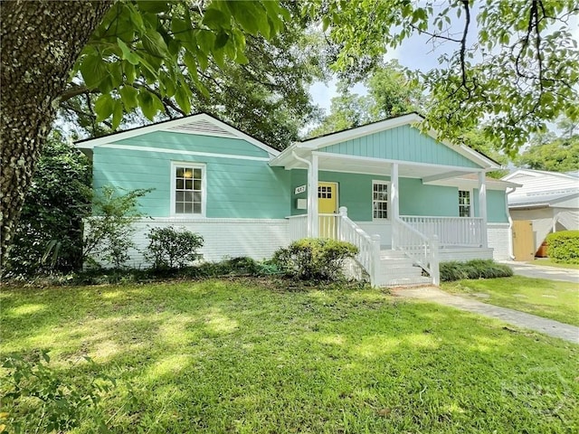 417 E 65th St, Savannah, GA 31405 - view of front of property featuring covered porch, brick siding, and a front yard