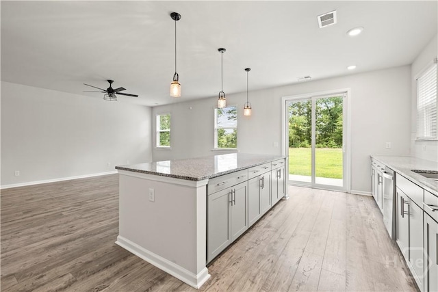 136 Ramsey Way, Rincon, GA 31326 - kitchen with light wood finished floors, a kitchen island, light stone countertops, hanging light fixtures, and recessed lighting