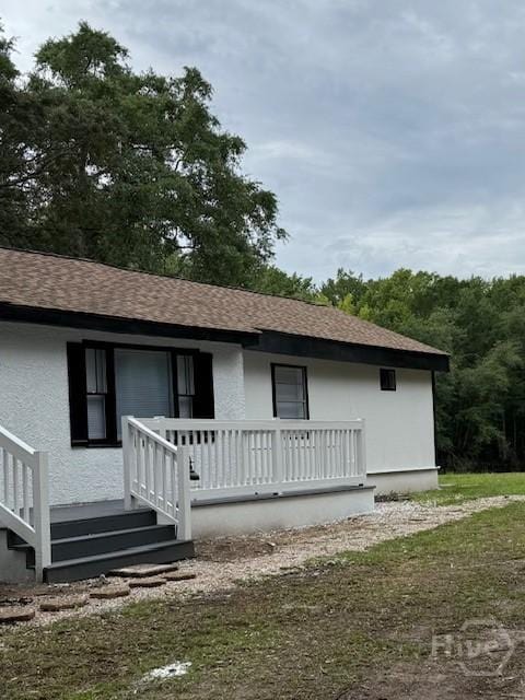 12 Jaguar Ln, Savannah, GA 31419 - rear view of property featuring covered porch, roof with shingles, and stucco siding