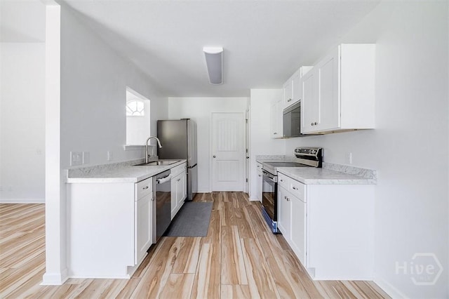140 Abigail Cir, Ellabell, GA 31308 - kitchen with appliances with stainless steel finishes, light wood-style floors, light countertops, and white cabinets