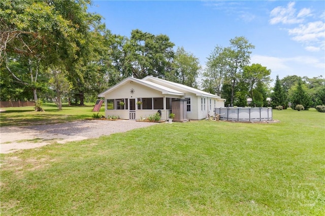 1072 Burtons Ferry Highway, Sylvania, GA 30467 - view of front of property with a sunroom, a covered pool, a front lawn, and view of wooded area