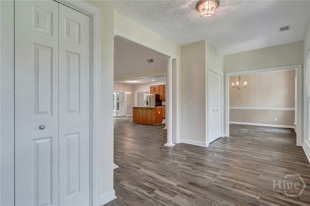 600 Old Louisville Rd, Guyton, GA 31312 - corridor featuring a chandelier, dark wood-type flooring, a textured ceiling, and decorative columns