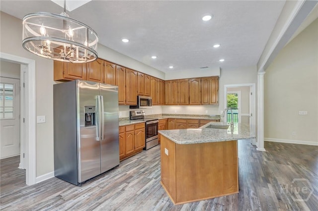 600 Old Louisville Rd, Guyton, GA 31312 - kitchen featuring appliances with stainless steel finishes, light wood-type flooring, light stone countertops, recessed lighting, and a center island