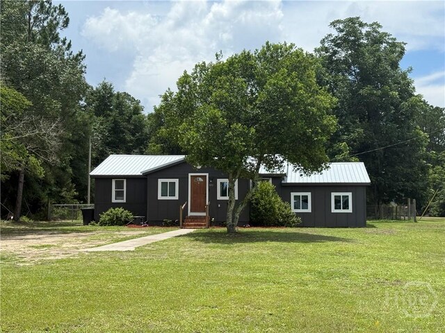 3052 Effingham Hwy, Sylvania, GA 30467 - view of front of property featuring board and batten siding, entry steps, a front yard, and a metal roof