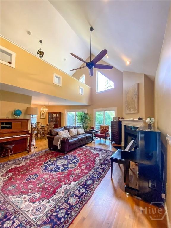 606 Dancy Ave, Savannah, GA 31419 - living room featuring wood finished floors, ceiling fan, a chandelier, high vaulted ceiling, and a fireplace
