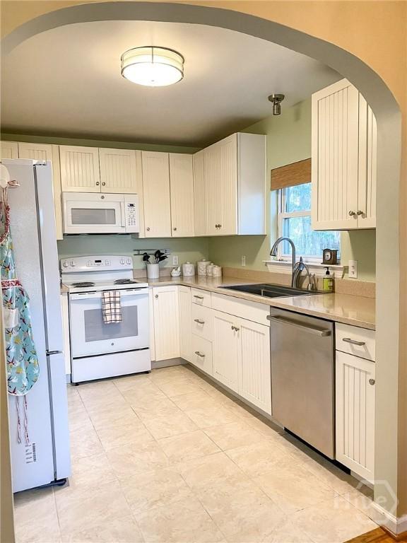 606 Dancy Ave, Savannah, GA 31419 - kitchen with white appliances, arched walkways, and light countertops